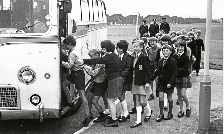 Pupils get on board a school shuttle 
bus service that served the academy 
while an extension was built