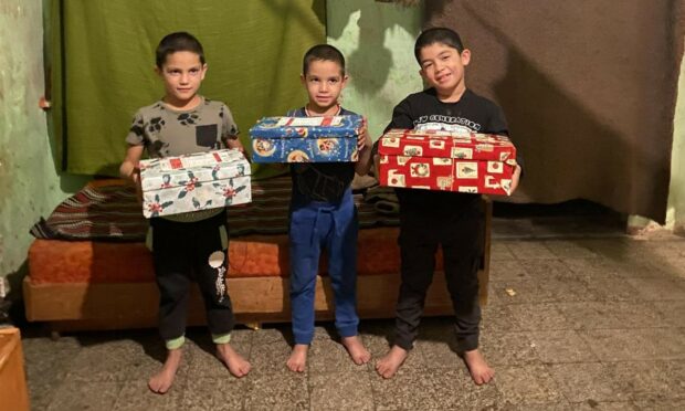 Brothers Rikardo, Jozsef and Zoltan from Ozd, northern Hungary, receive their boxes