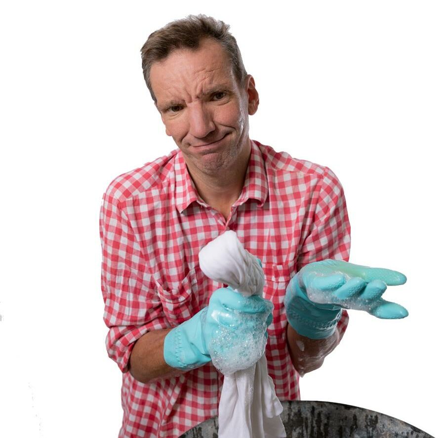Henning Wehn wearing a read and white checkered shirt and light blue washing gloves.