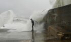 Waves crashing over harbour in Cullen last month. Picture by Jason Hedges.