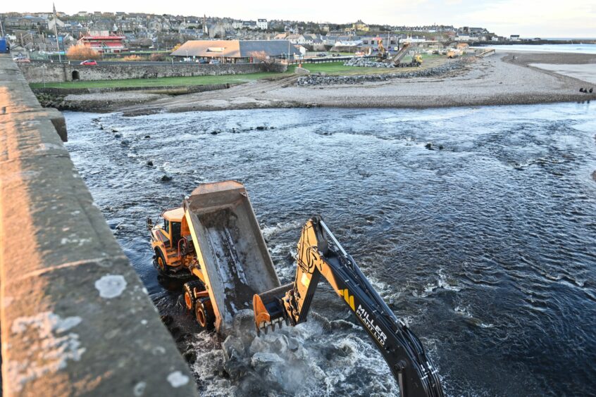 A digger in the water working on Banff Bridge