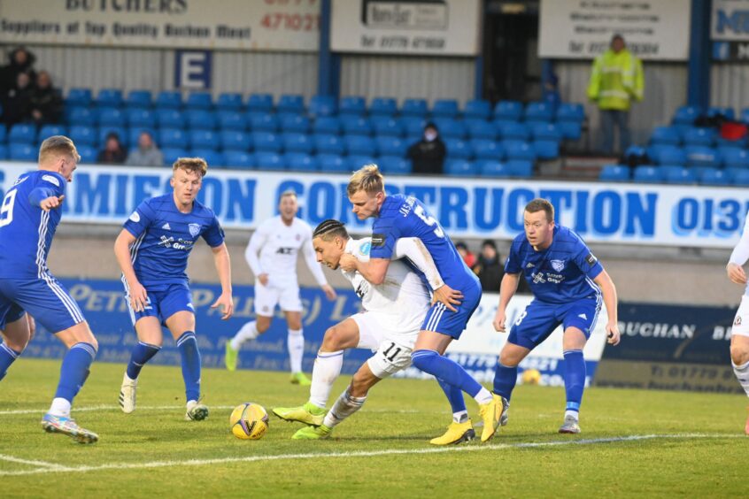 Peterhead defender Jason Brown tries to keep Cove Rangers forward Leighton McIntosh at bay