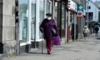 A woman wears a mask on a street in Ellon. Picture by Kenny Elrick