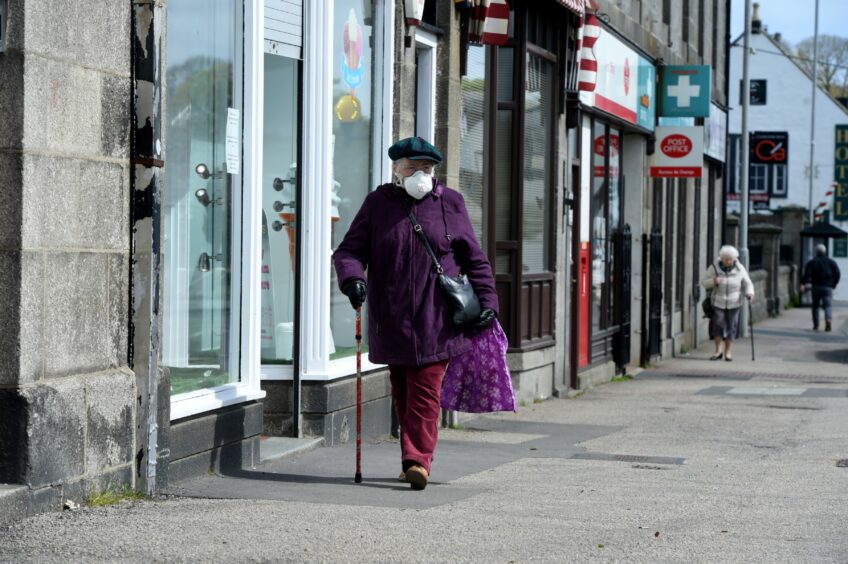 Elderly woman wearing a mask outdoors to protect herself from Covid.