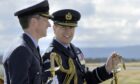 Prince Andrew smiles in RAF uniform while supervising a parade at RAF Lossiemouth