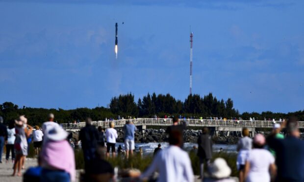 Crowds on the beach watch the latest SpaceX rocket launch at Cape Canaveral, Florida.