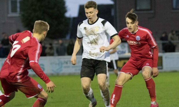 Clach's Harry Nicolson attempts to get arounf Brechin No16 Marc Scott and Cameron Ross