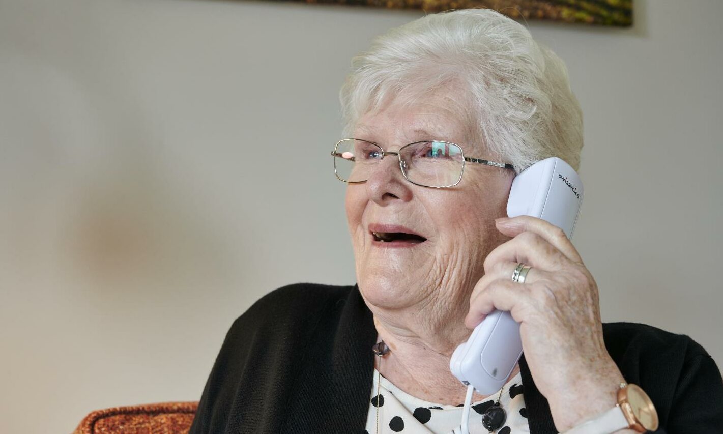 A woman chats on the phone to her Sight Scotland Veterans volunteer befriender