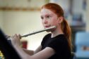 Girl playing flute as part of national youth orchestras Scotland applications.