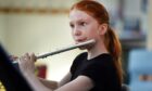 Girl playing flute as part of national youth orchestras Scotland applications.