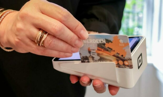 Someone holding and swiping Aberdeen Gift Card.
