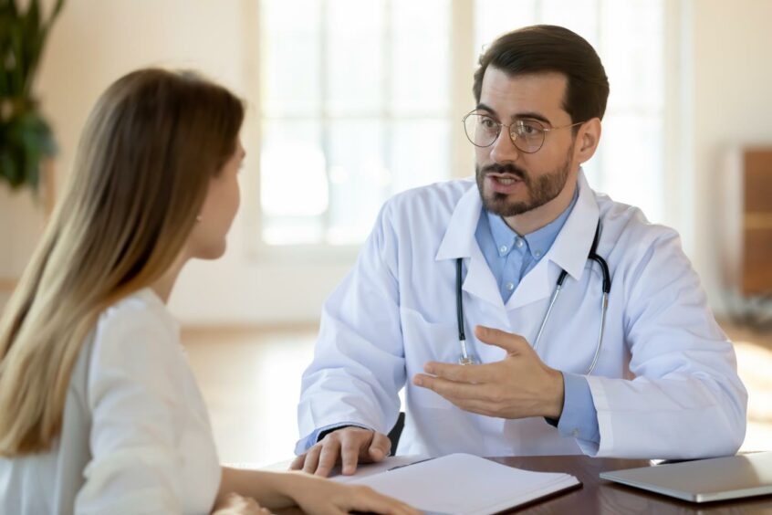 Woman speaking to a male GP