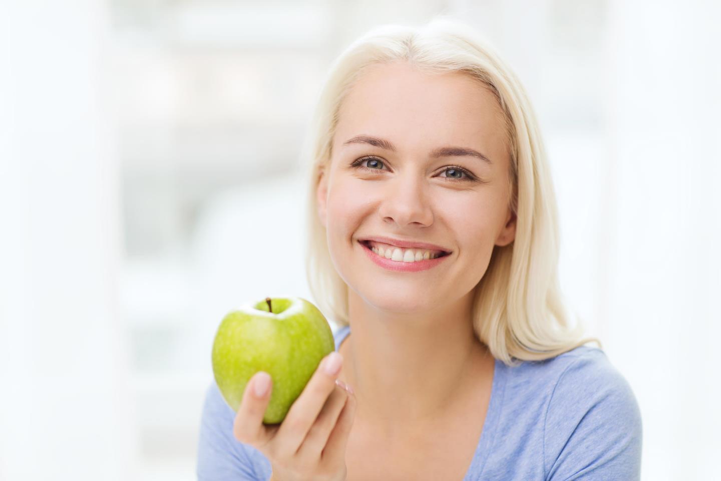 Woman eating a green apple