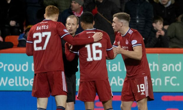 Three Aberdeen players talking to a referee.