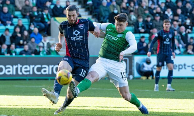 Ross County defender Alex Iacovitti clears from Hibs striker Kevin Nisbet.