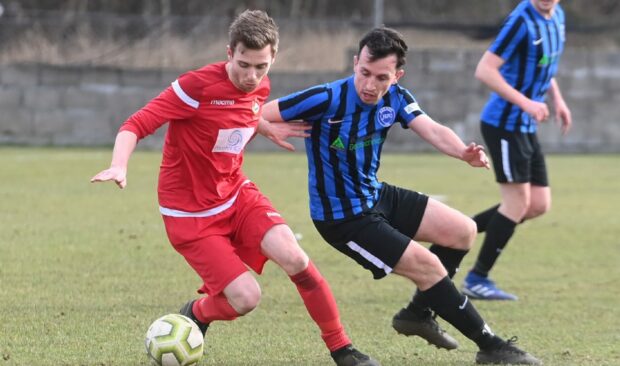 Hermes' Callum Innes (blue) and Hall Russell United's Andrew Davidson (red). Picture by Chris Sumner