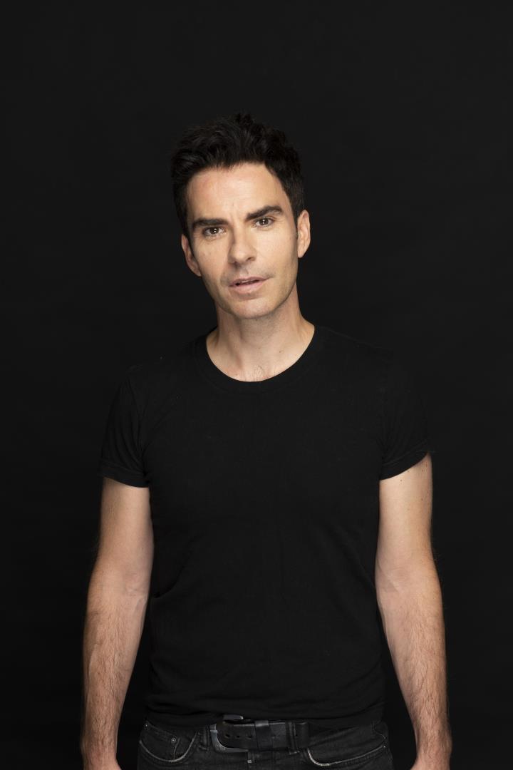 Kelly Jones wearing a black t-shirt on black background