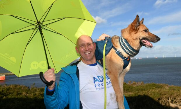 Robert Strachan out with an umbrella and his pet German Shepherd dog