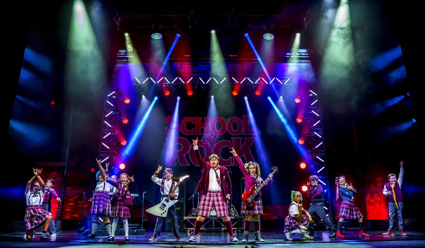 cast rocking out in school of rock production 