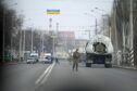 A Ukrainian soldier stands next to a military vehicle on a road in Kramatosrk, eastern Ukraine, Thursday, Feb. 24, 2022.