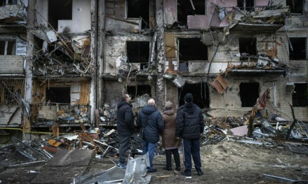 People look at the damage following a rocket attack the city of Kyiv, Ukraine. AP Photo/Emilio Morenatti