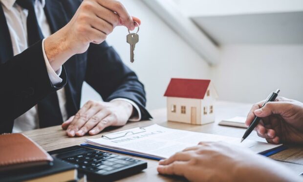 Estate agent giving house keys to client