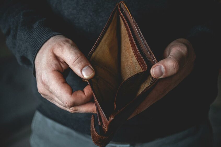 Man holding an open wallet with no money inside