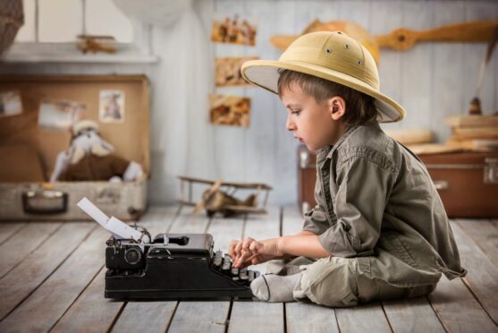 Little boy in pith helmet with typewriter