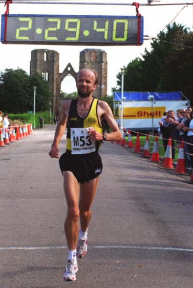Fraser Clyne crosses the finishing line of the Moray Marathon as the clock indicate 2.29.40