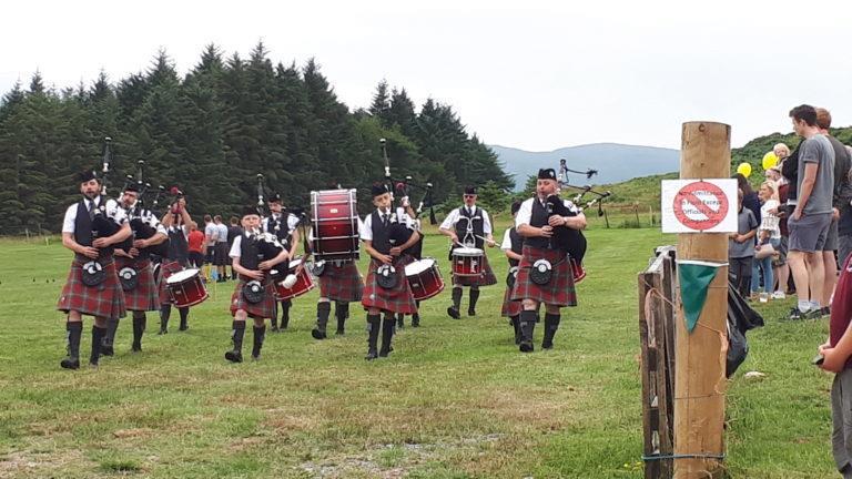 A pipe band walks across the field