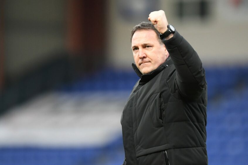 Ross County manager Malky Mackay pumps a celebratory fist in the air.