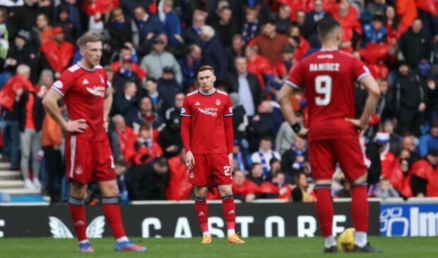 The Aberdeen players are dismayed at conceding a late goal at Ibrox.