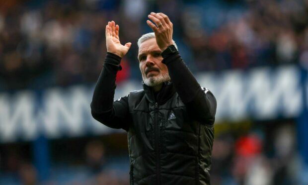 Aberdeen manager Jim Goodwin applauds the travelling fans after the 1-0 loss at Rangers.
