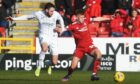 Connor Barron of Aberdeen and Hibernian's Drey Wright compete for the ball