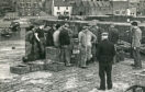 It's 1955 and men gather round for the mid-day sale of fish at Gourdon