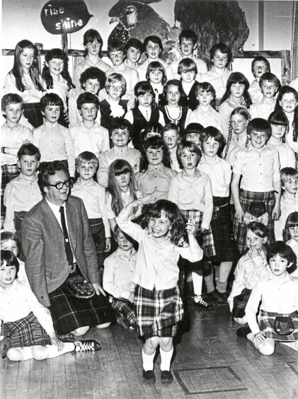 Black and white photo of a young girl dancing in front of a group of children
