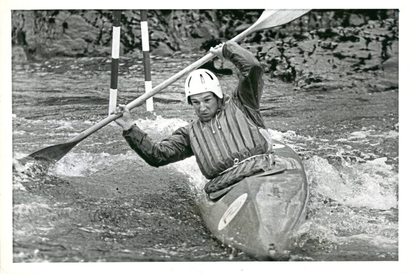 Black and white photo of a man in a river slalom race