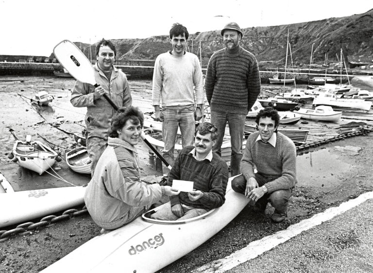 Six people from Stonehaven Canoe Club pose for the camera on the shore