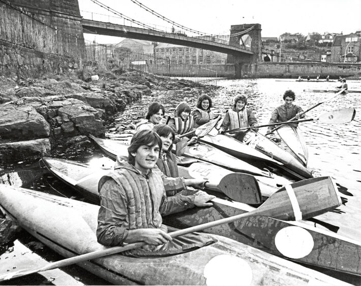 Group of canoeists from Aberdeen University Canoe Club lined up on the side of the river