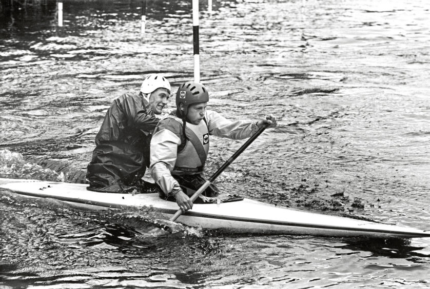 Two men from Aberdeen Kayak Club participating in a slalom on a a two-person canoe