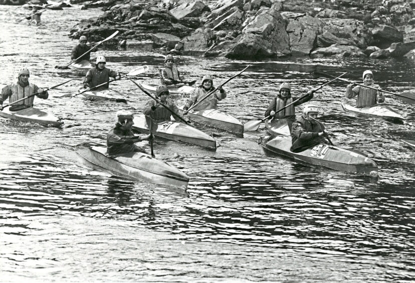 Black and white photo of Aberdeen University Canoe Club's canoeists paddling down the river
