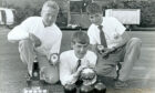Three boys holding junior singles bowling trophies.