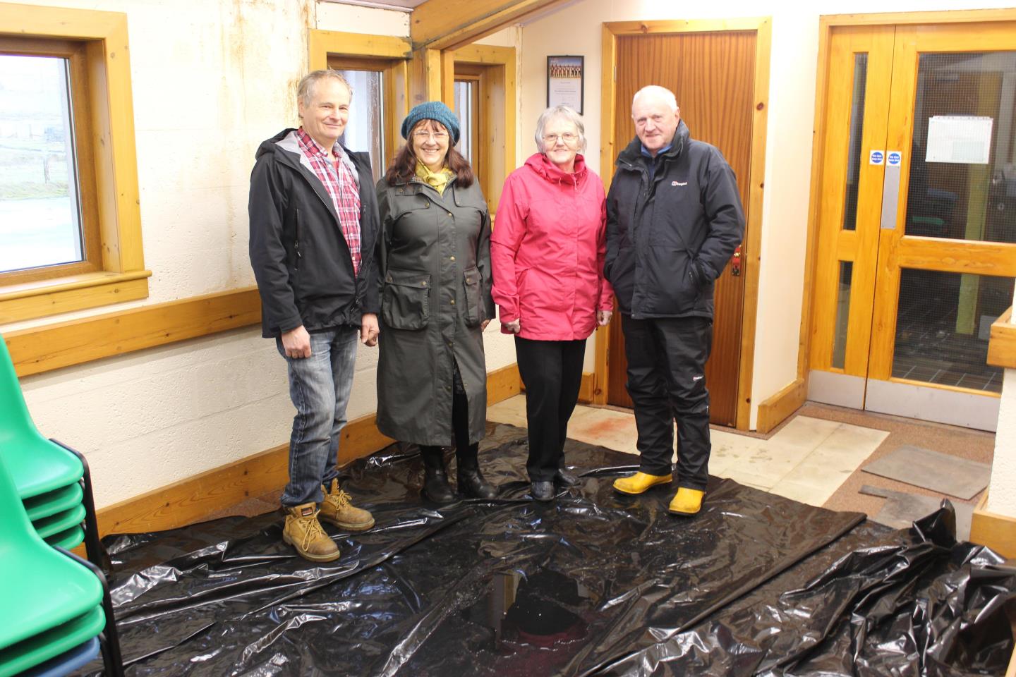 Berneray Community Association committee members Nigel Buckley, Joanne Vincent, Chrissie MacAskill and Iain MacKillop pictured on a recent wet day, which necessitated the spreading of a tarpaulin on the hall floor to catch the incoming water.