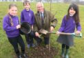 Plant a tree for the jubilee: Kininmonth pupils Lia Noble, 8, Kaileb Wallace, and Jessica Legarda, 6 with Deputy Lord Lieutenant of Aberdeenshire, Douglas Fowlie.