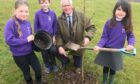 Plant a tree for the jubilee: Kininmonth pupils Lia Noble, 8, Kaileb Wallace, and Jessica Legarda, 6 with Deputy Lord Lieutenant of Aberdeenshire, Douglas Fowlie.