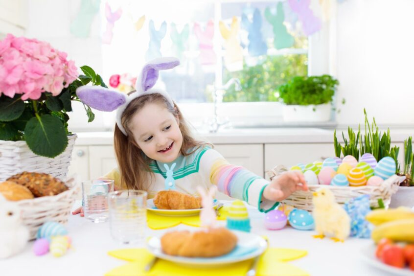 Picture shows: Young girl at table with Easter decorations. 