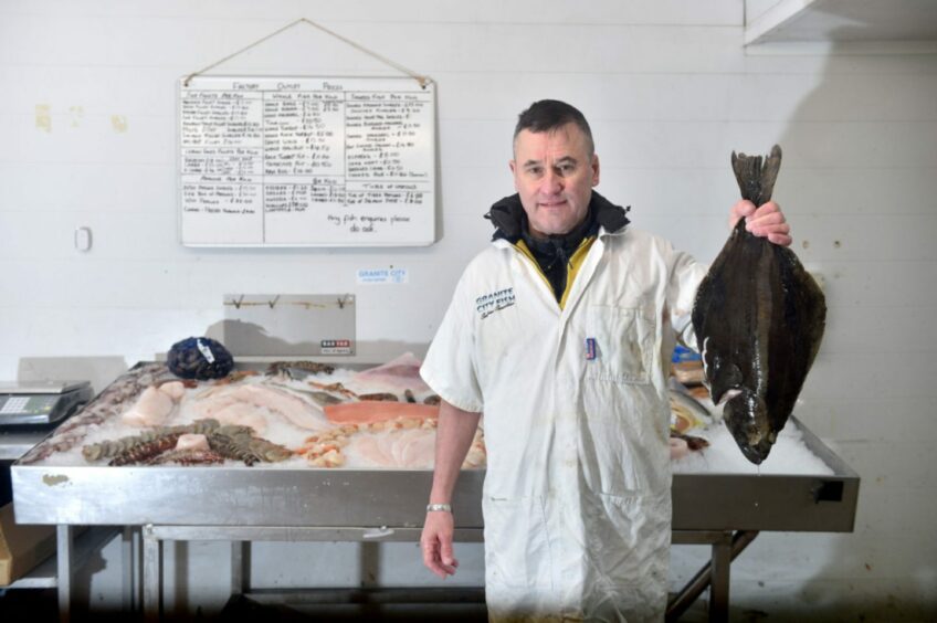 Fishmonger holds up a fish