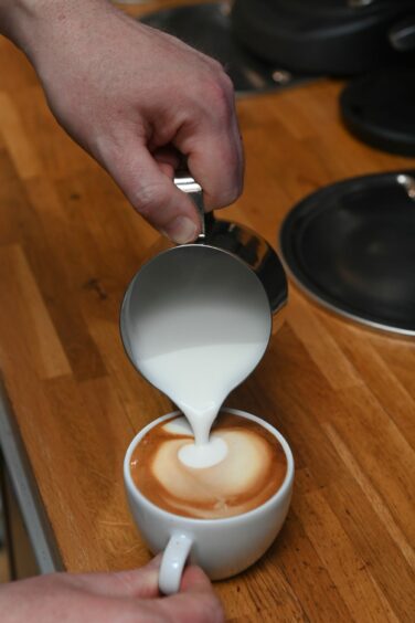 Silk-smooth milk being poured in a coffee mug