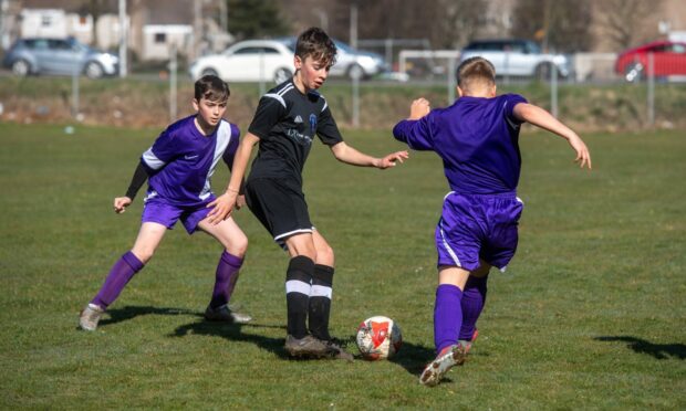 St Machar close in on Westhill's Matthew Grassick. Picture by Kath Flannery