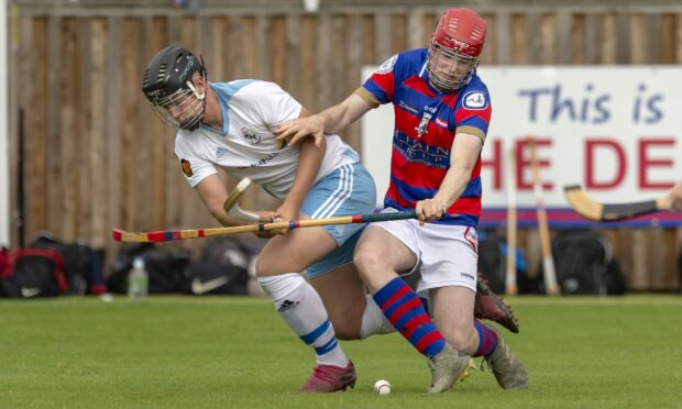 Skye's Ross Gordon and Calum Grant (Kingussie) challenge for the ball in a MacTavish Cup match at The Dell.